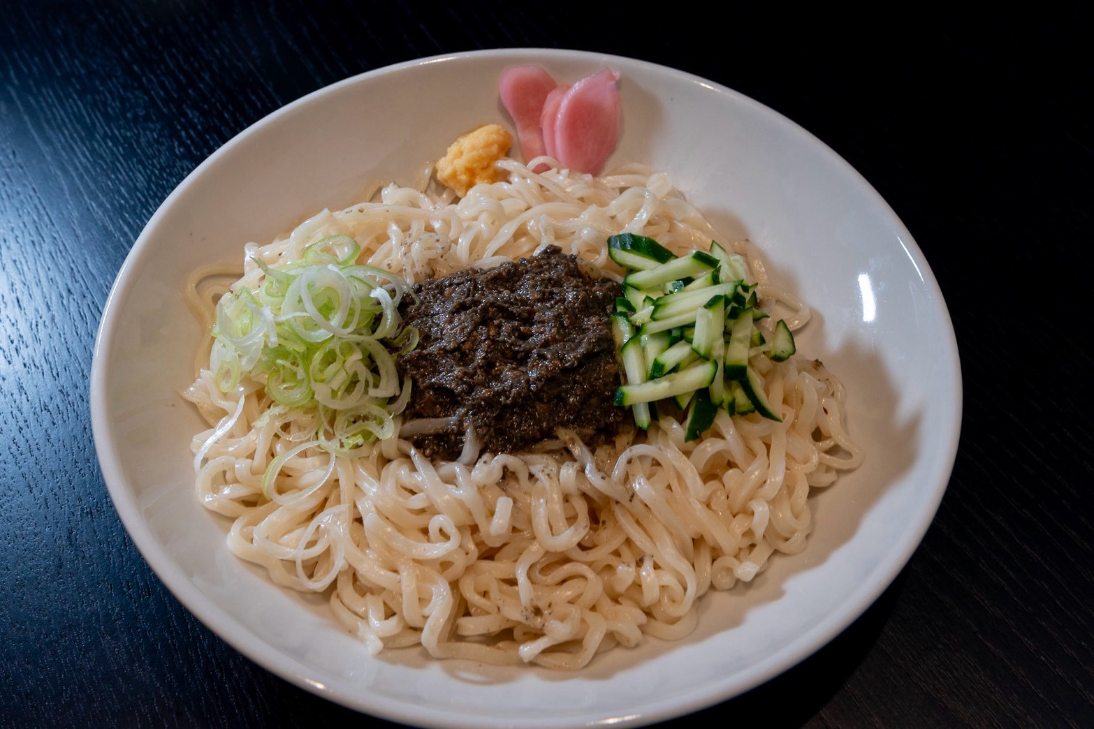 真上から見たじゃじゃ麺。肉みそ、きゅうり、ねぎ、生姜をのせて。